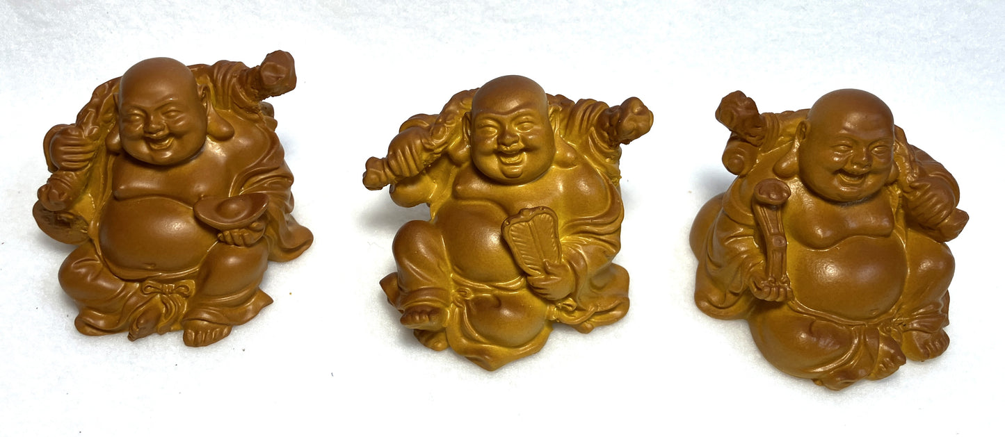 Three Laughing Buddha figurines shown close up on a white background