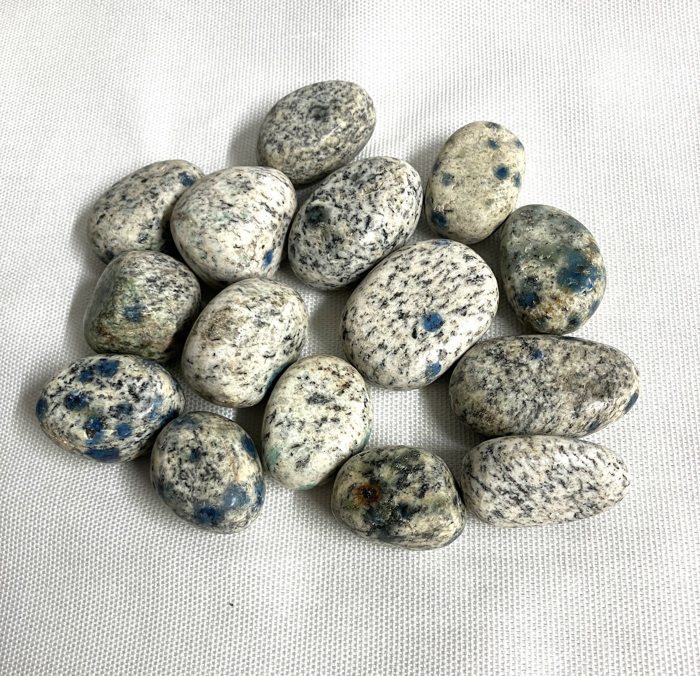 Back side of the K2 Crystals showing the speckled pattern on a white fabric background