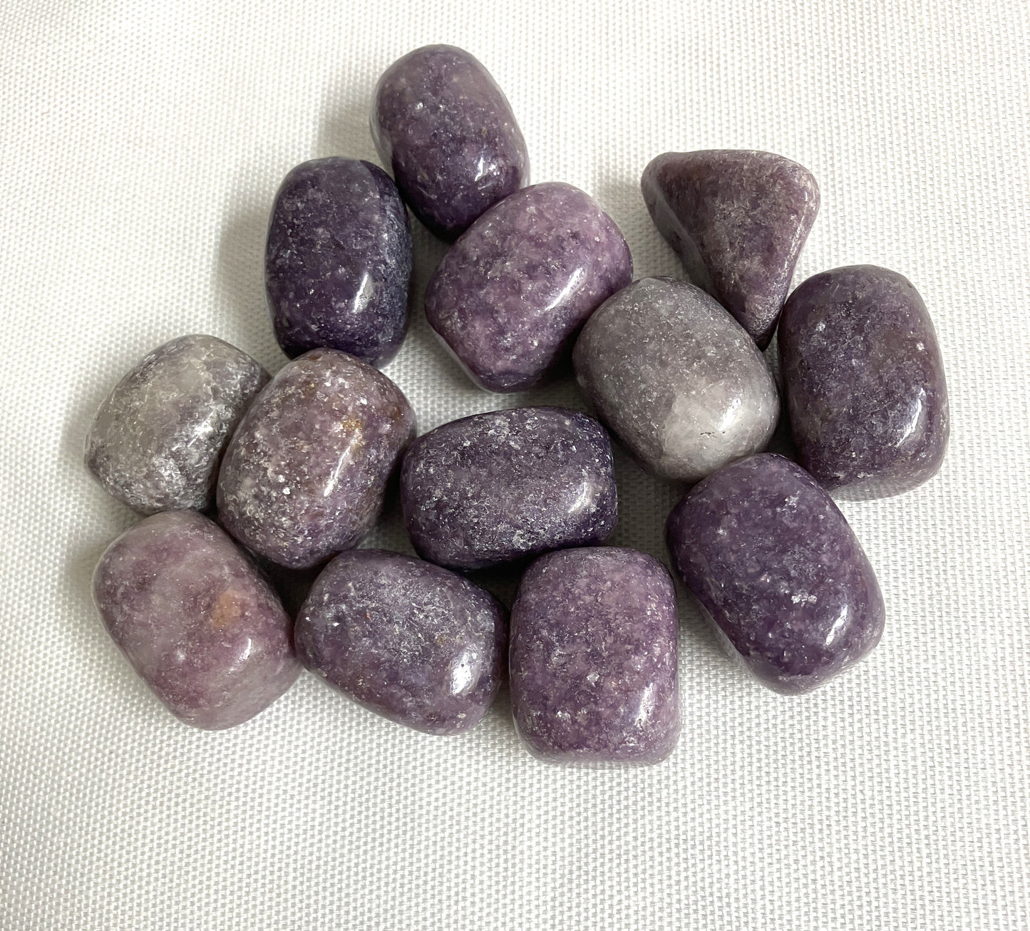 Back side of Lepidolite Crystals on a white fabric background