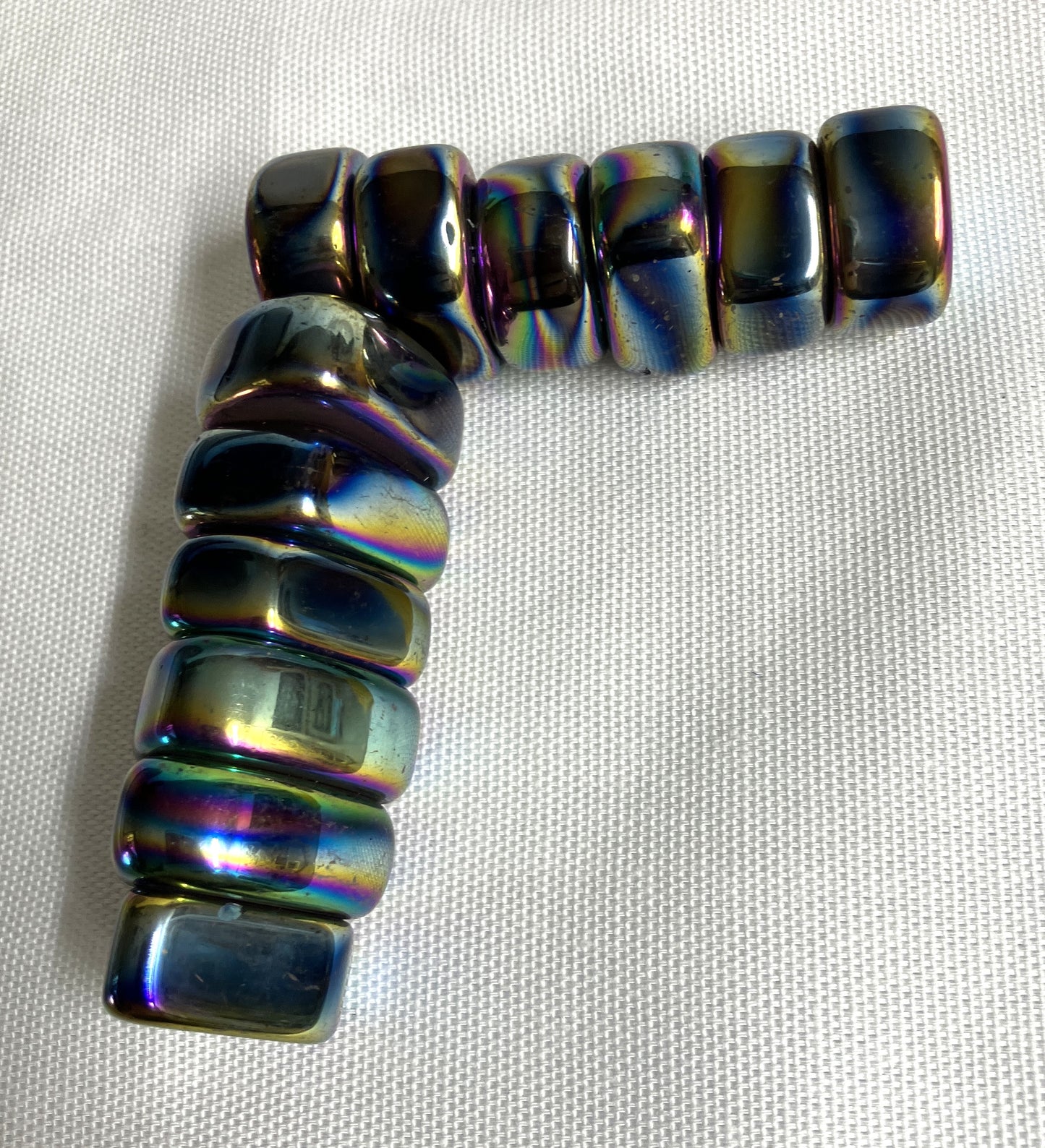 Magnetic Rainbow Hematite Crystals on a light fabric background