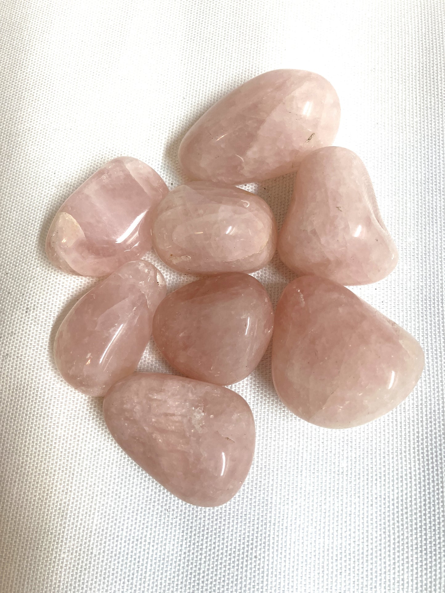 Group of Rose Quartz Crystals on a white fabric background