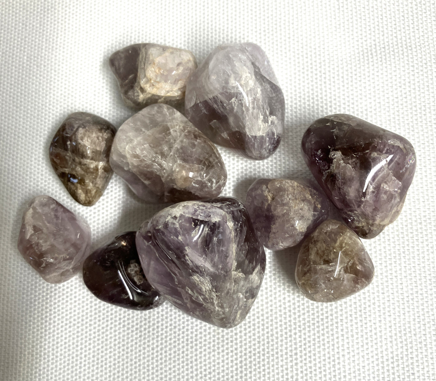 Collection of Super Seven Crystals aka Melody's Stone shown on a white fabric background