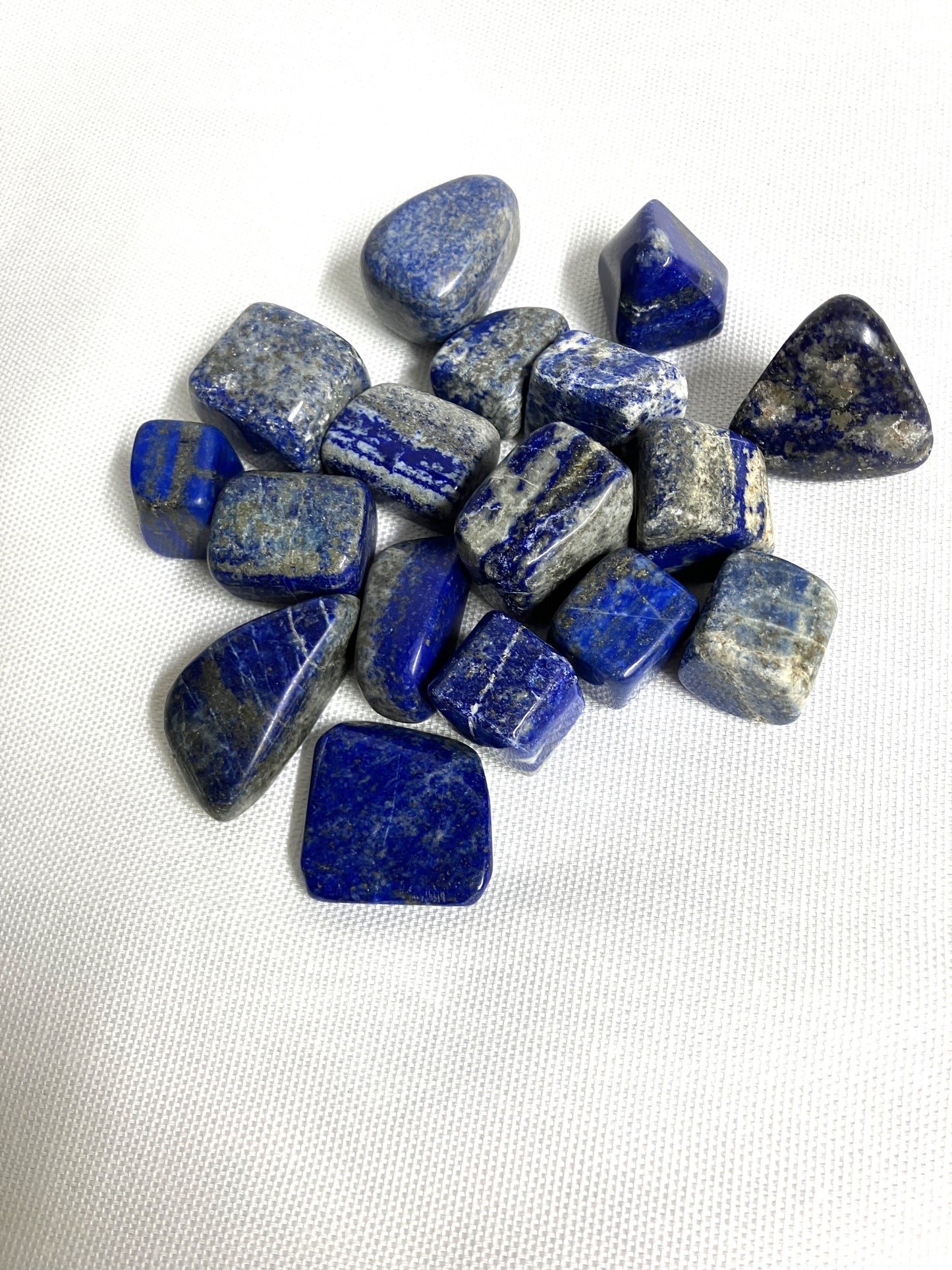 Back view of Lapis Lazuli Crystals on a white fabric background