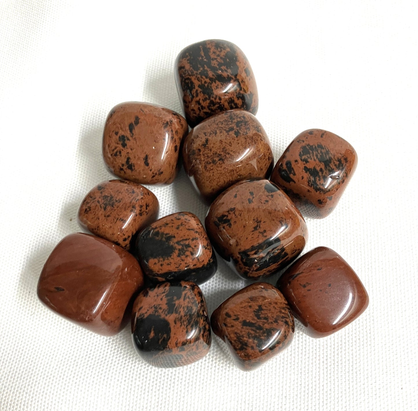 Closeup of Mahogany Obsidian Crystals on a white fabric background