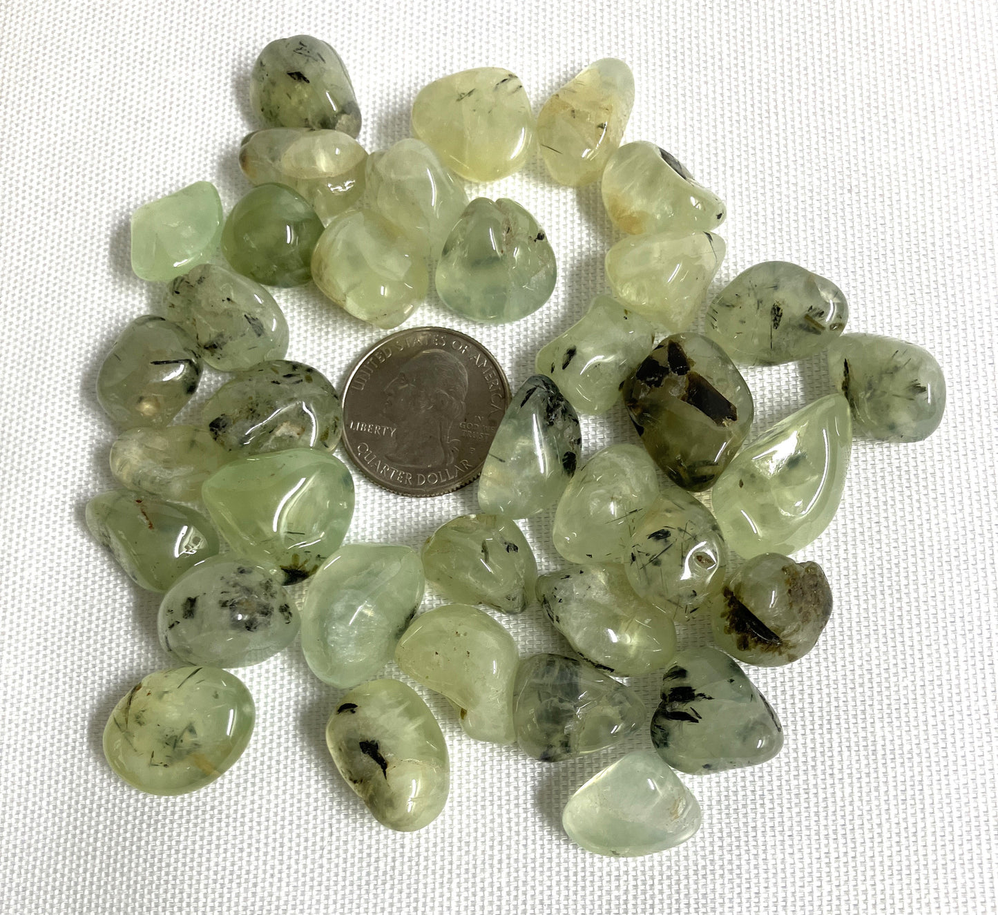 Prehnite with Epidote Crystals back side shown with a quarter for scale on a white background