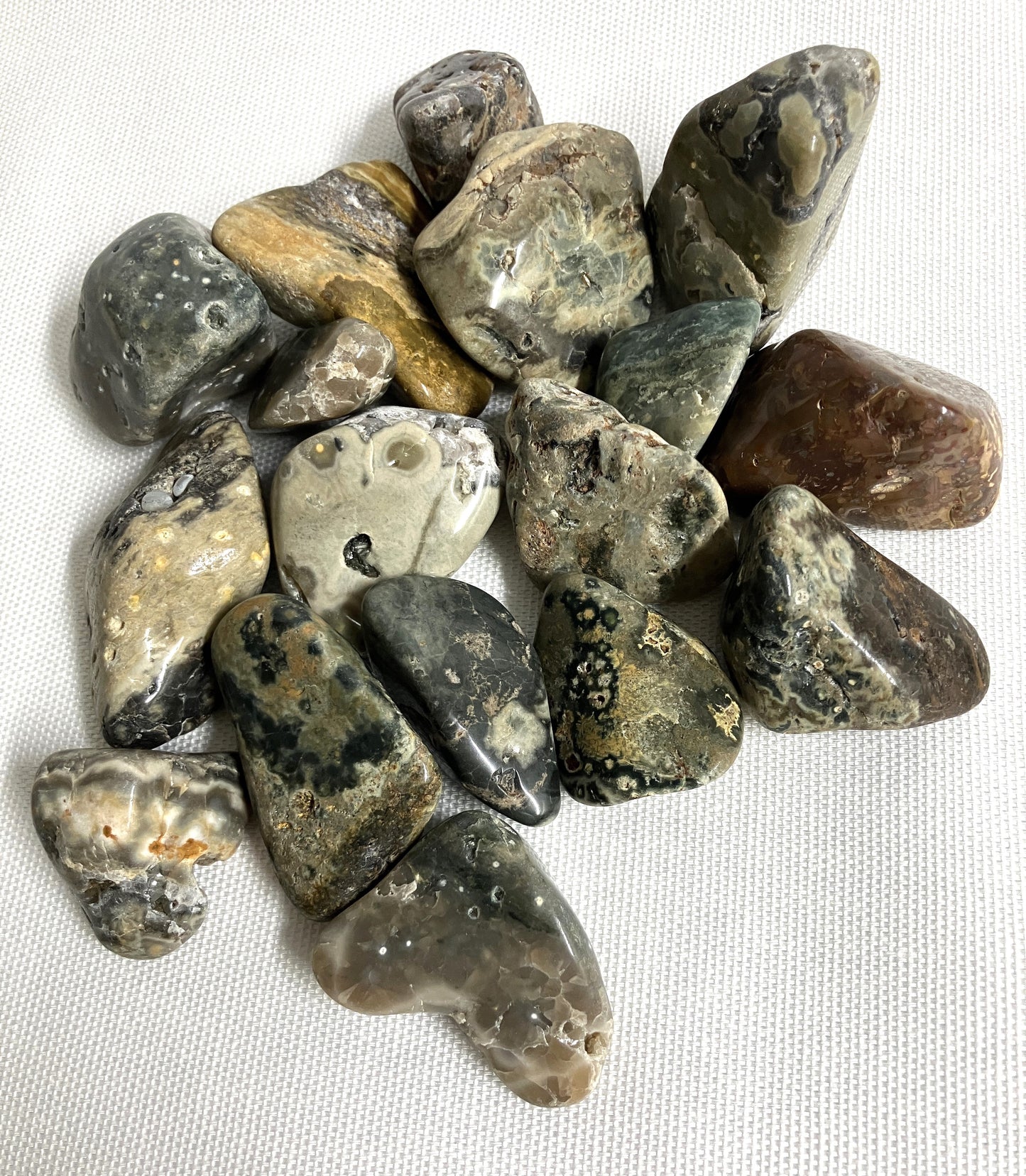 Closeup of variously shaped and sized Ocean Jasper Crystals on a white background