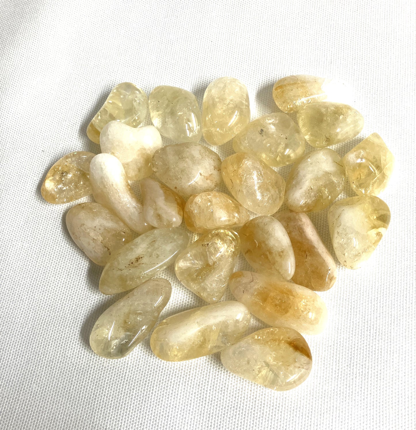 Bottom view of Citrine Tumbled Crystals on a white background