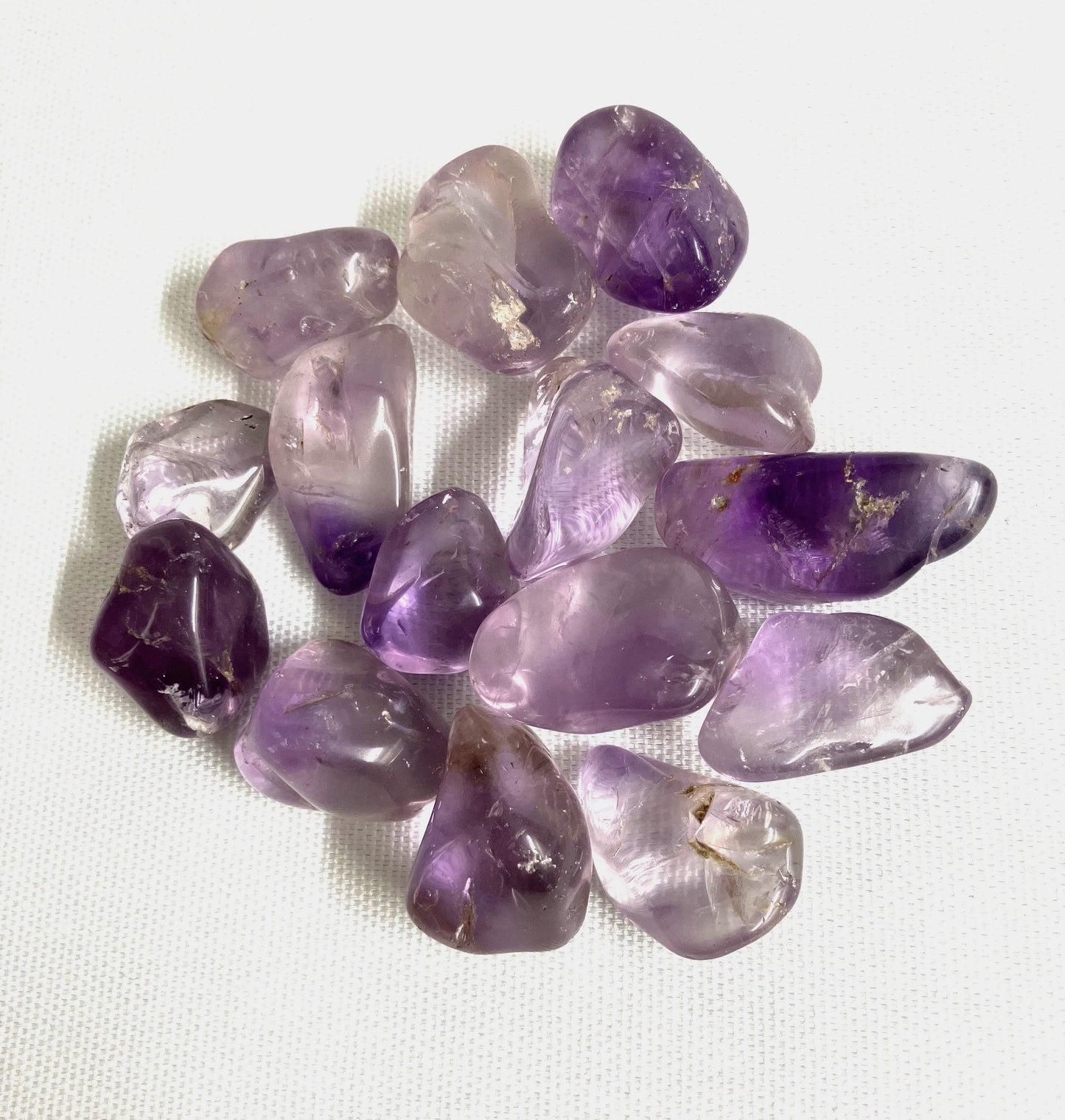 Another view of Amethyst Crystals on a white fabric background