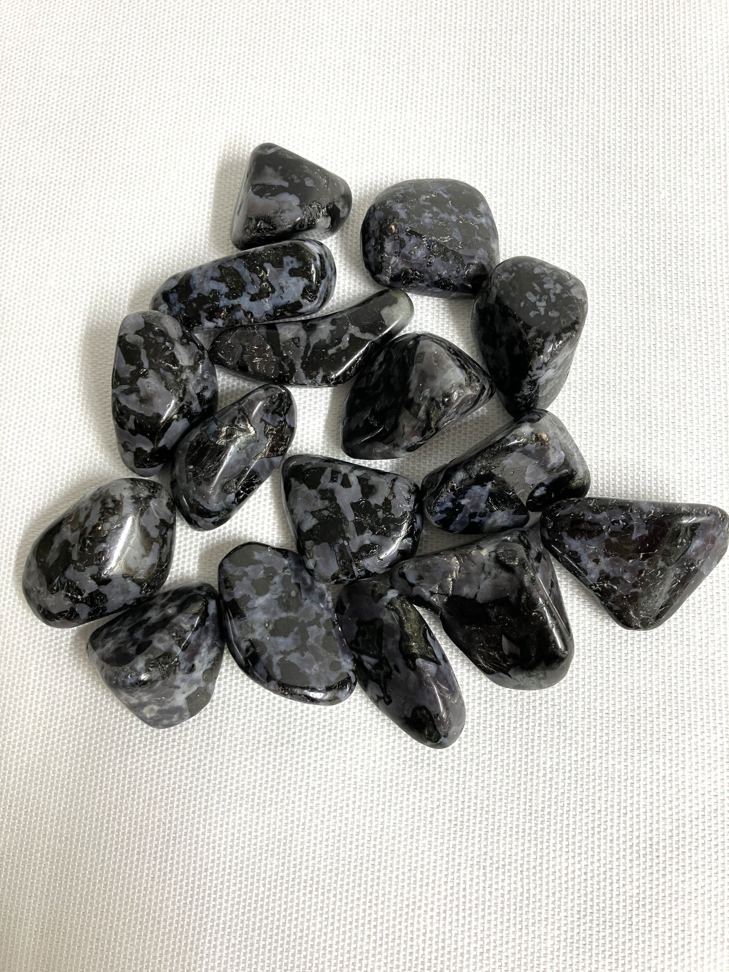 Closeup view of Indigo Gabbro Tumbled Crystals on a white background