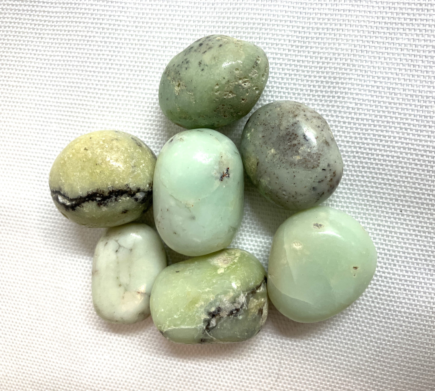Another view of Green Chrysoprase Crystals on a white fabric background