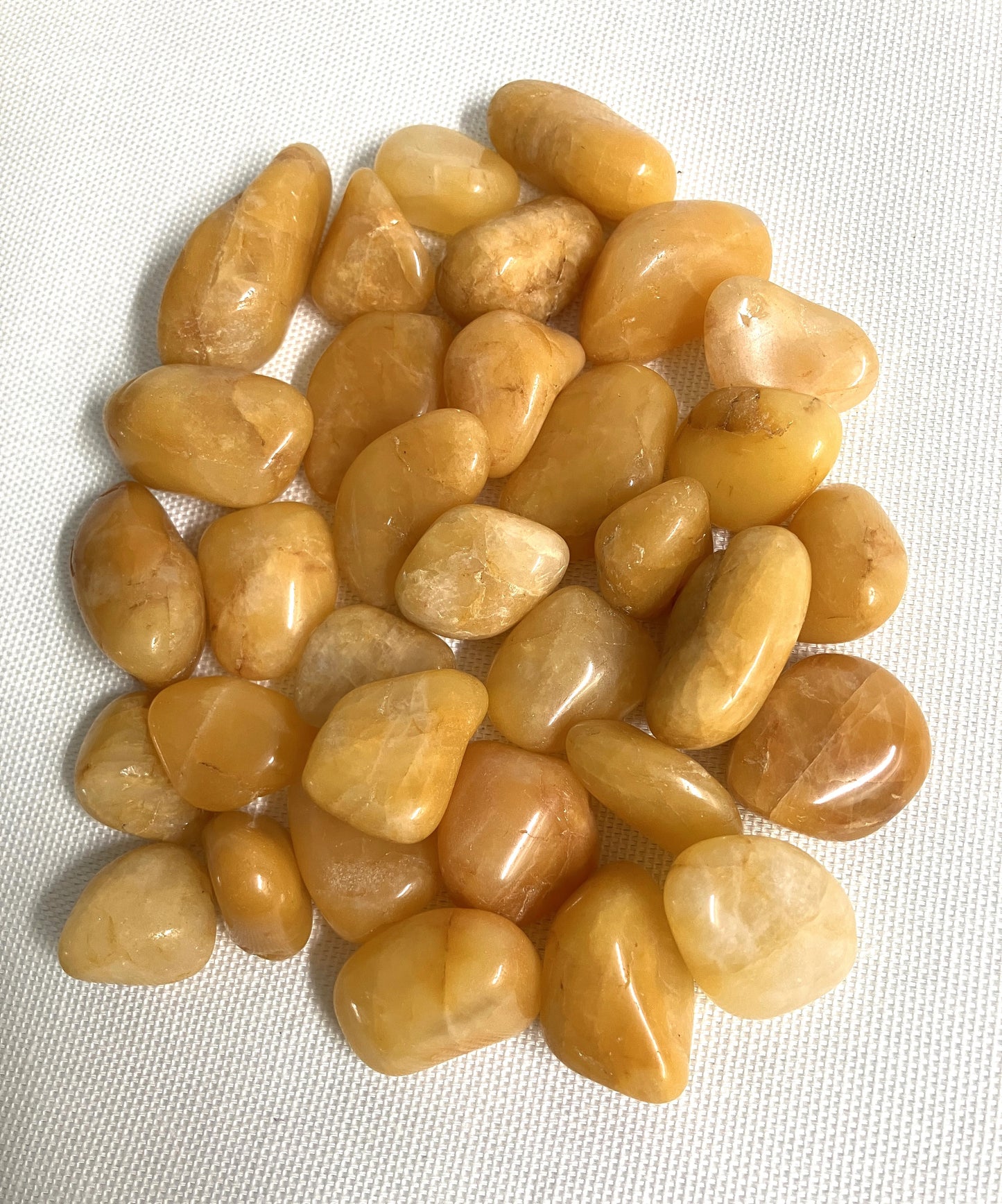 Arrangement of Apricot Quartz Crystals on a white fabric background