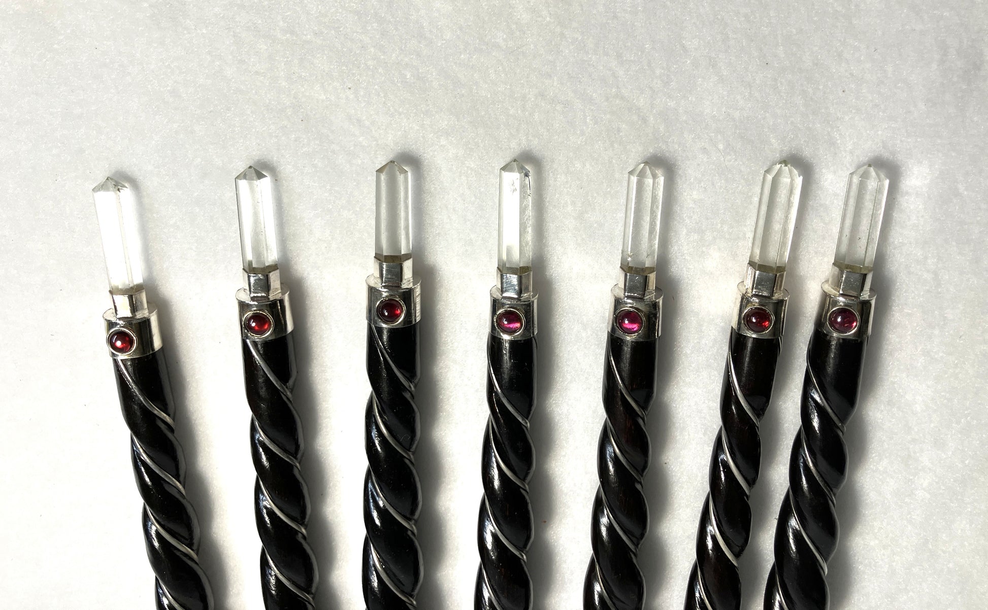 Group of twisted Rosewood wands showing the quartz points with a red dot and silver tone accents