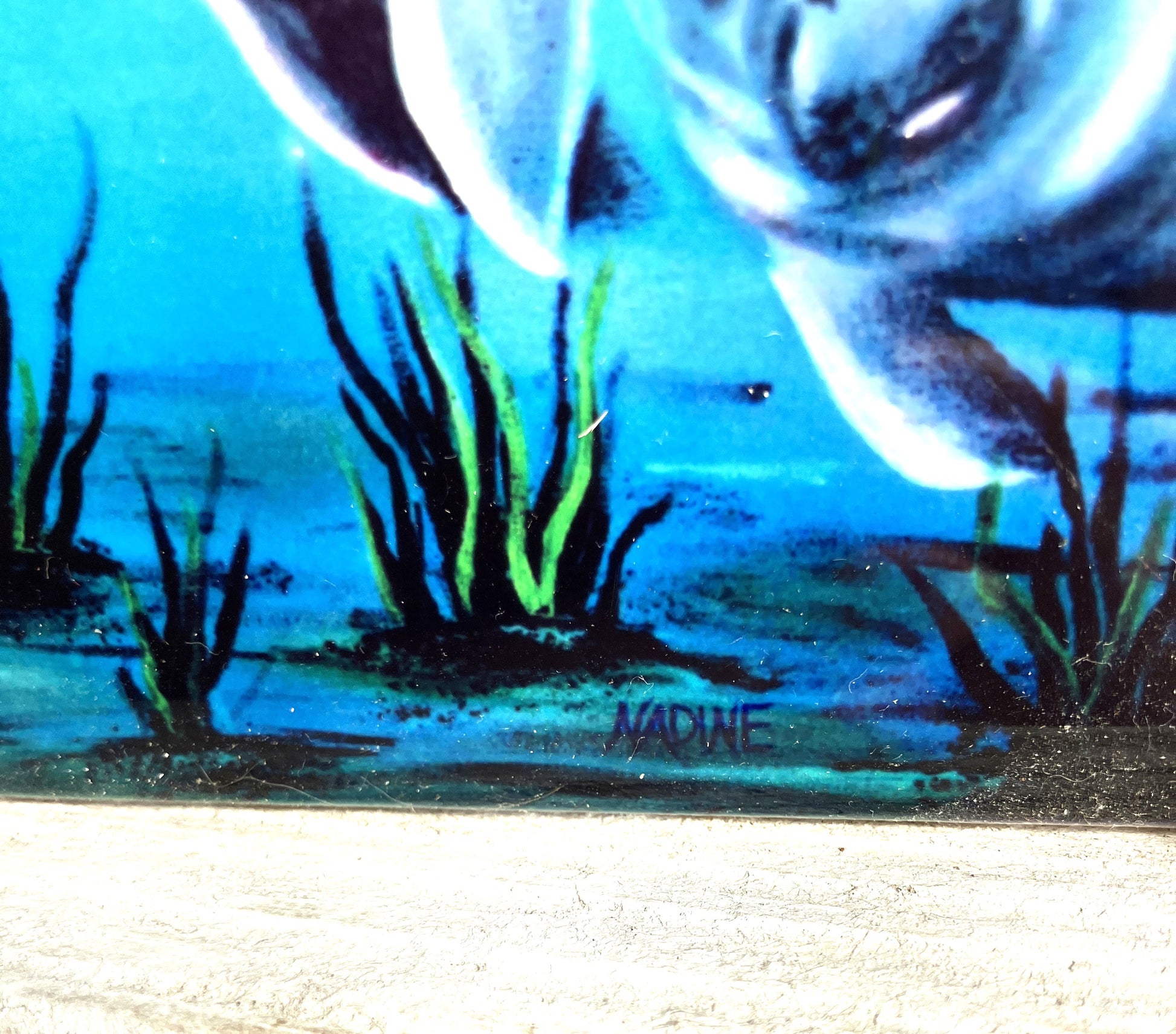 Close-up of the Manatee  painting with abstract elements and green grass-like shapes showing the artist's signature