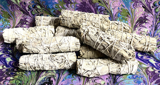Group of White Sage smudge sticks shown on a swirled color background