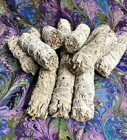 White sage smudge sticks on a colorful, swirling fabric background