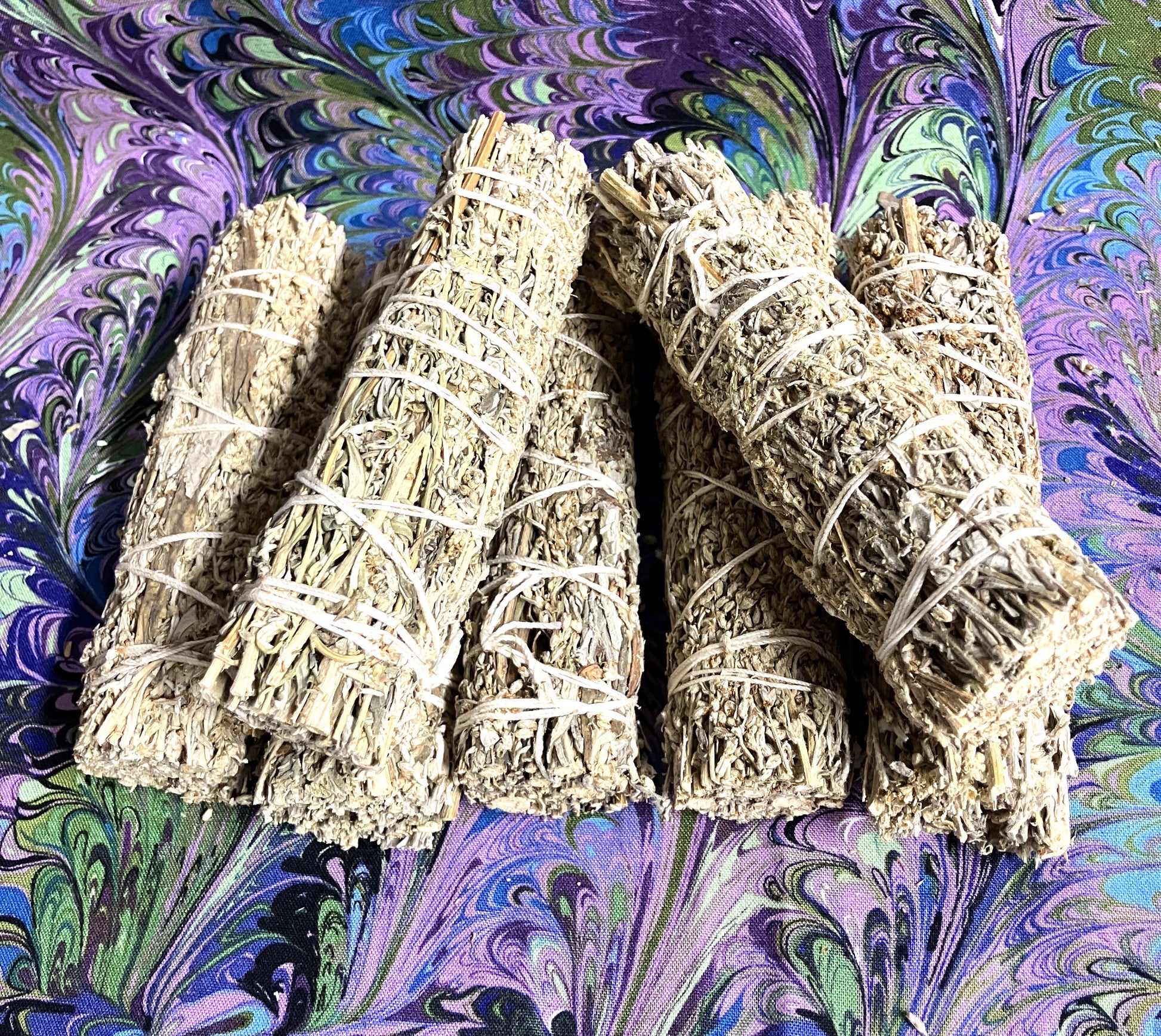 Seven bundles of Mugwort on a swirling purple and green background