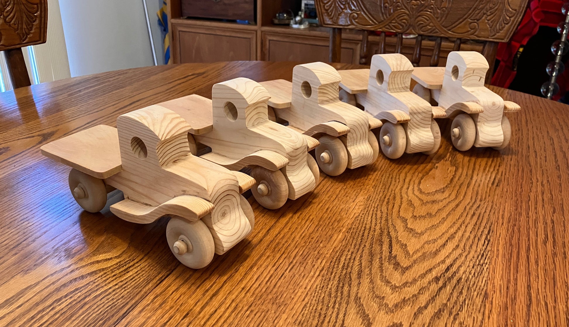 Set of wooden toy pickup trucks on a wooden table