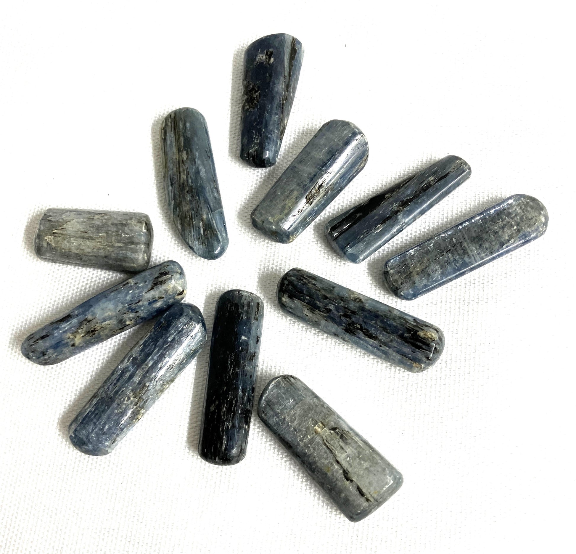 Blue Kyanite Crystals arranged in a circular pattern on a white background