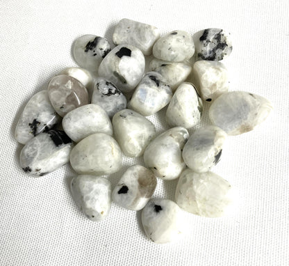 Tumbled Rainbow Moonstone Crystals  on a white fabric background