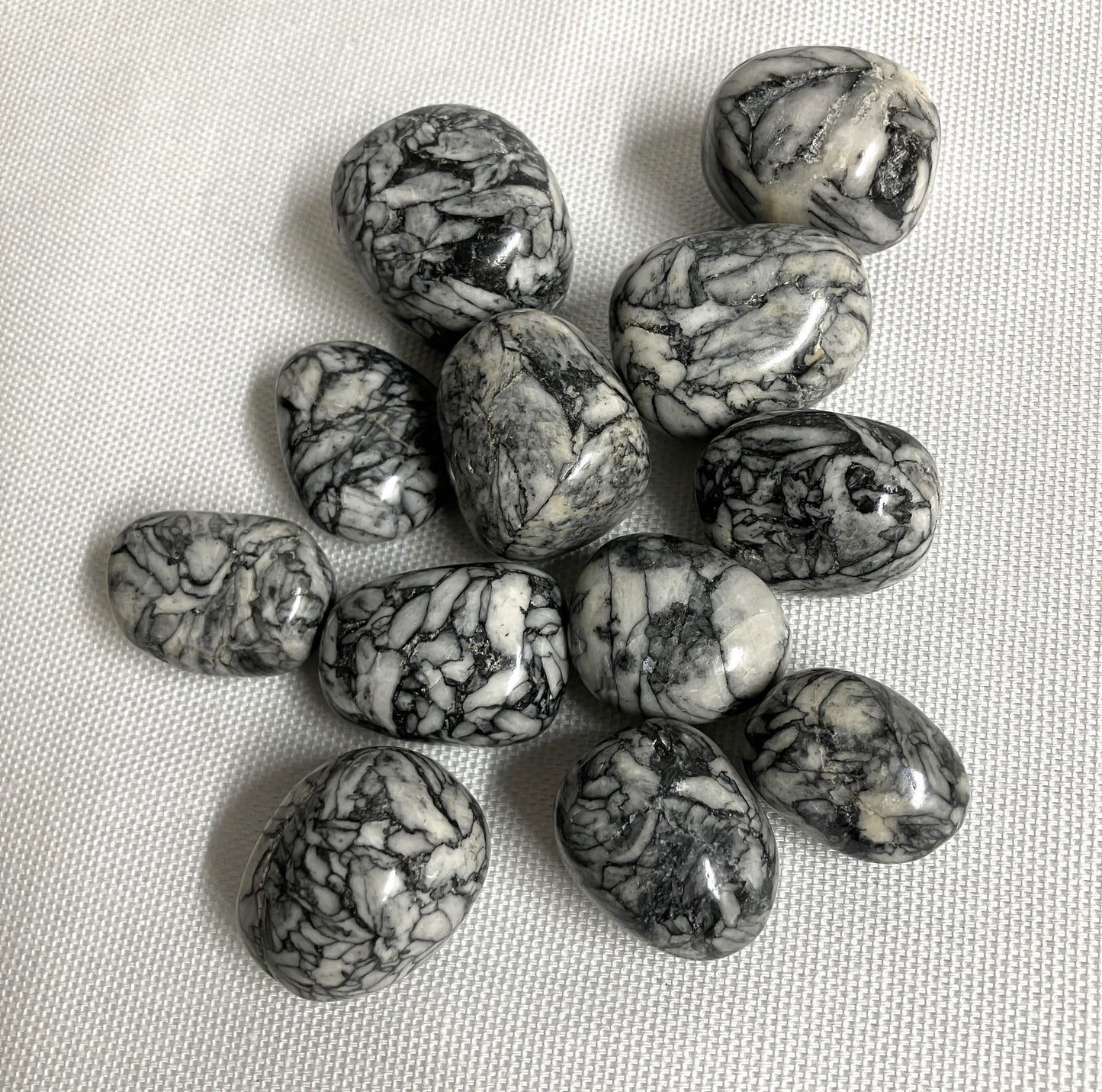 Collection of Pinolith Jasper Crystals on a textured beige surface