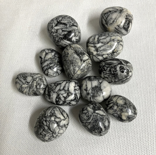 Collection of Pinolith Jasper Crystals on a textured beige surface