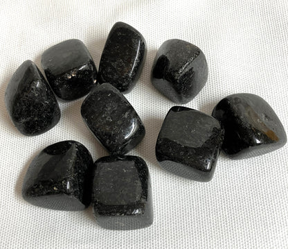 Nuummite Crystal AKA Sorcerers Stone displayed on a white fabric background