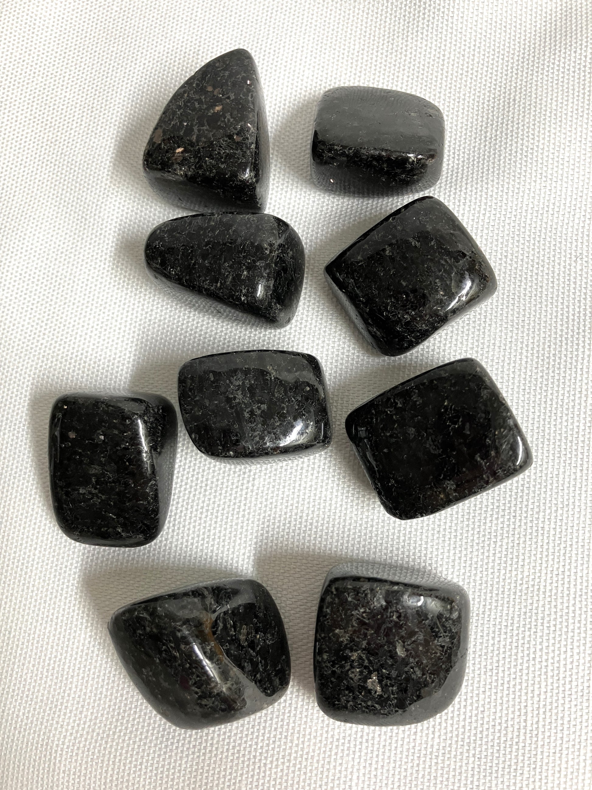 Nuummite Crystal AKA Sorcerers Stone grouping  on a white fabric background