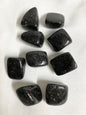 Nuummite Crystal AKA Sorcerers Stone grouping  on a white fabric background