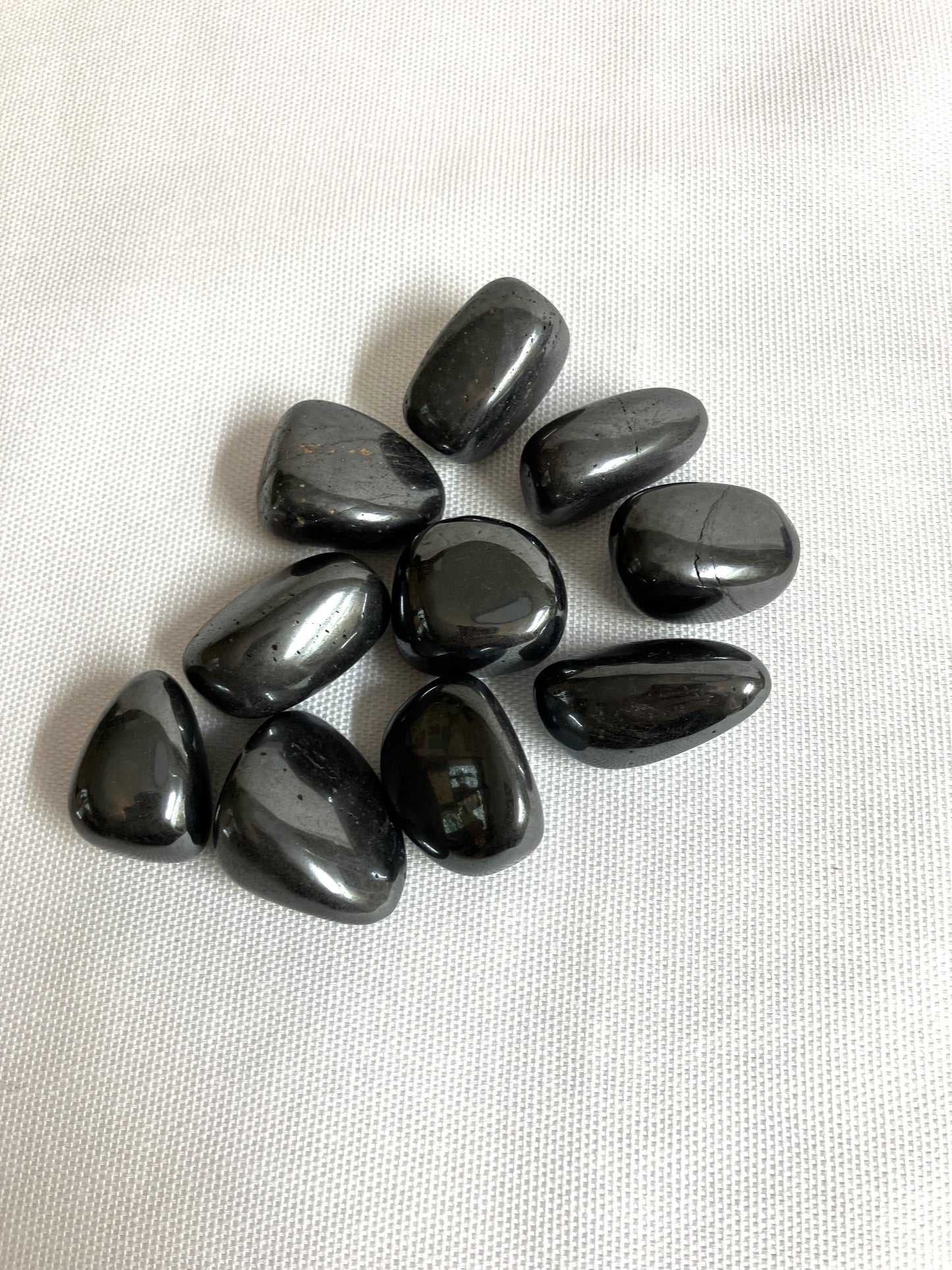 Top side of Hematite Crystals on a white fabric background