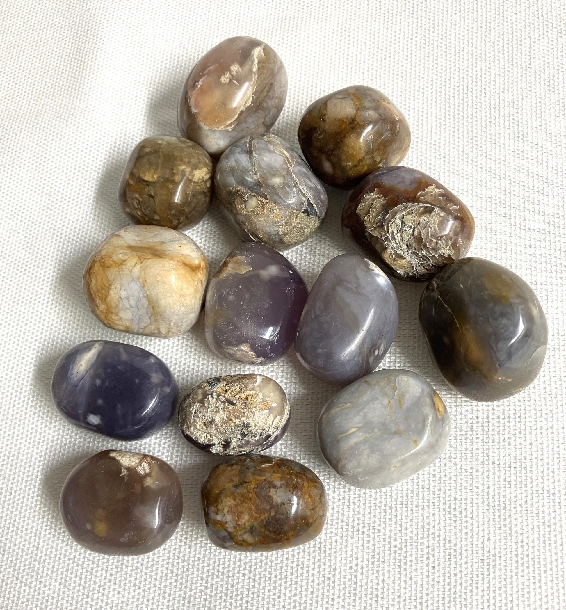 Front view of Purple Chalcedony Crystals shown on a white textured backing.