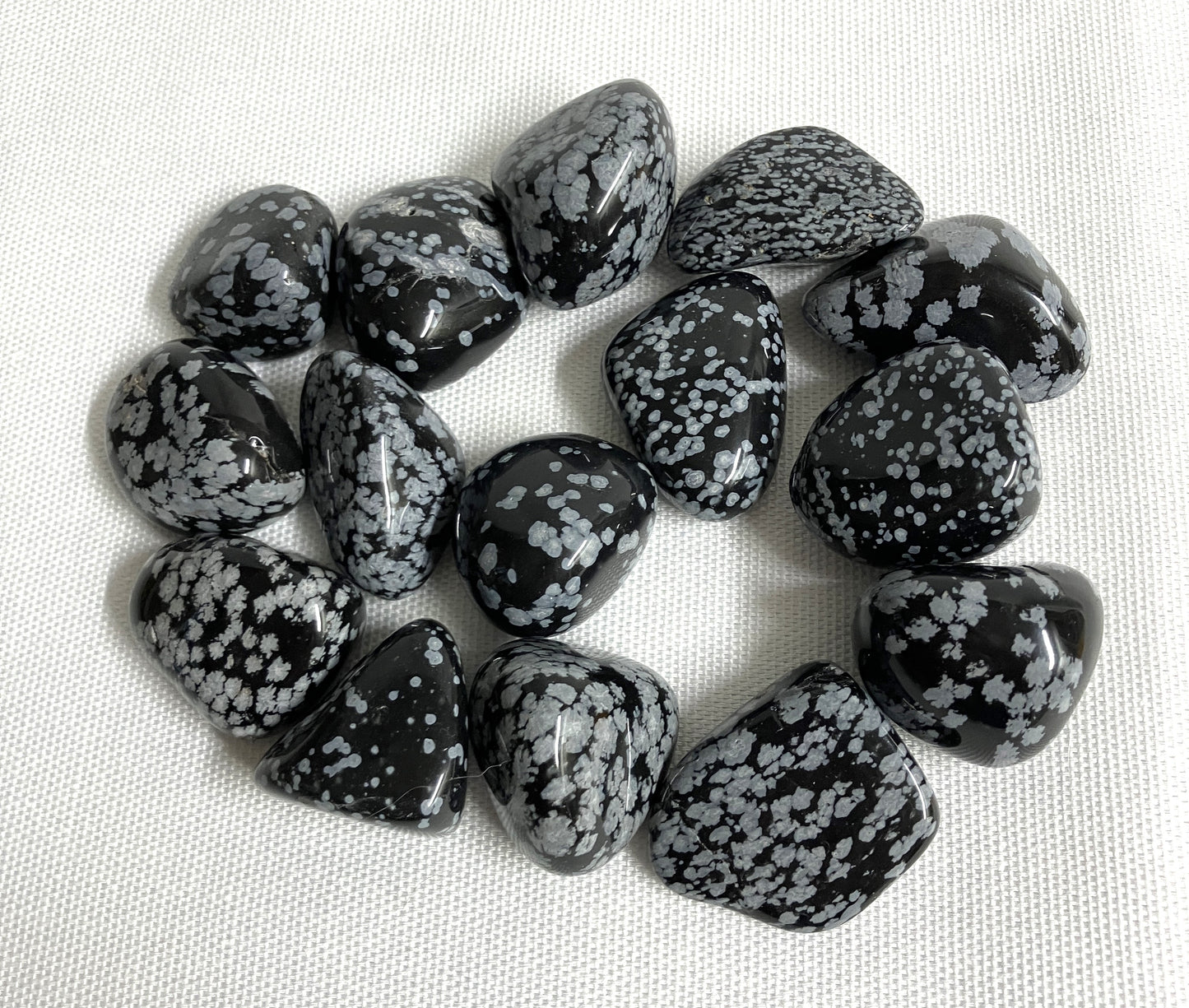 Snowflake Obsidian Crystals on a light fabric background