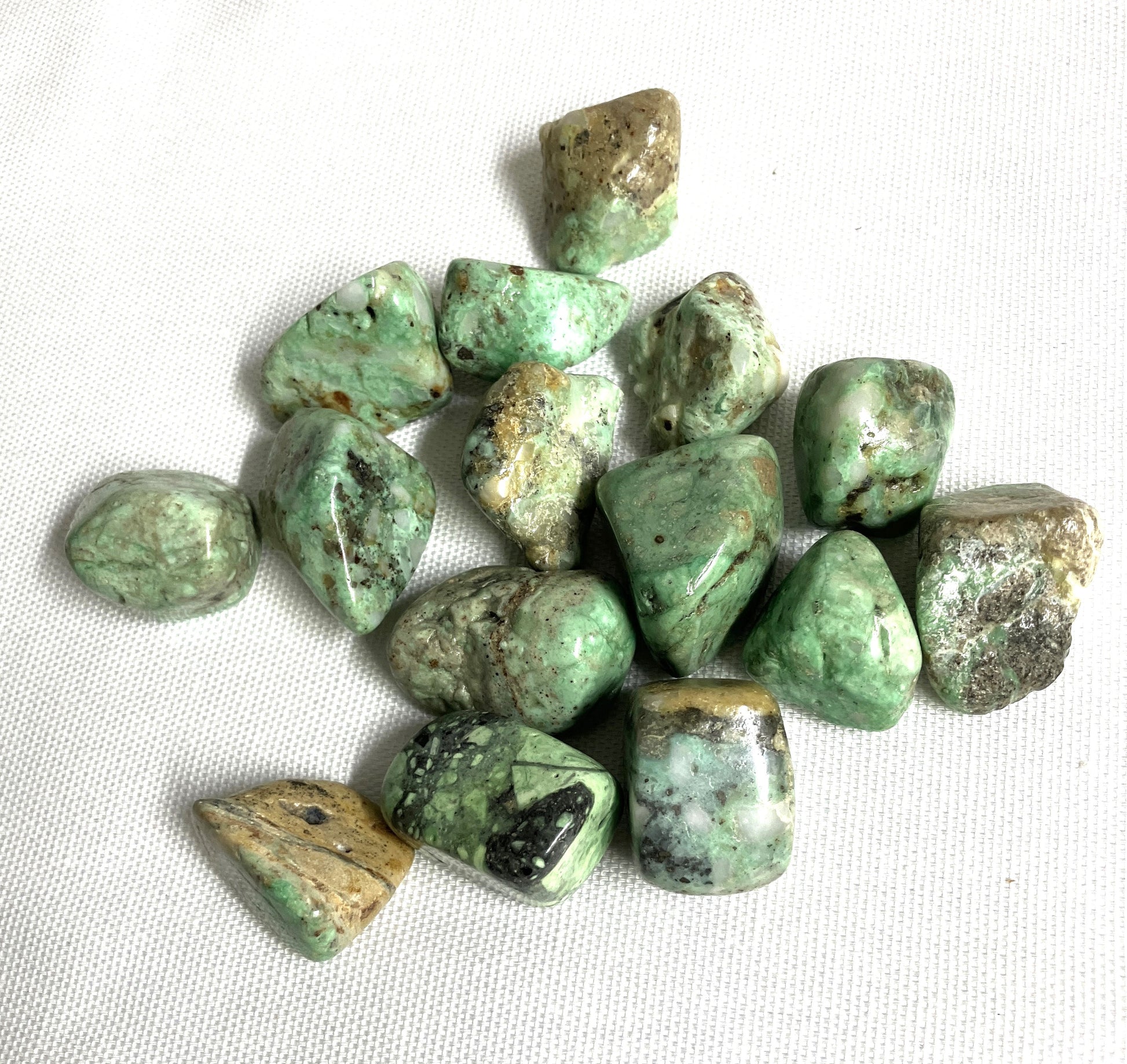 Tumbled Variscite Crystals on a white fabric background