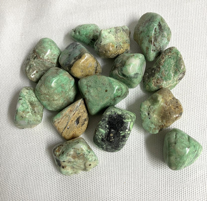 Collection of Variscite Crystals on a white fabric background front view