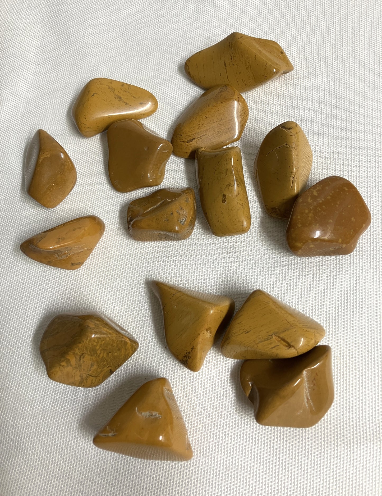 Front view of Yellow Jasper Crystals on a white fabric background