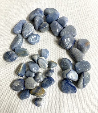 Collection of Blue Quartz Crystals front view arranged in a circular pattern on a white fabric background