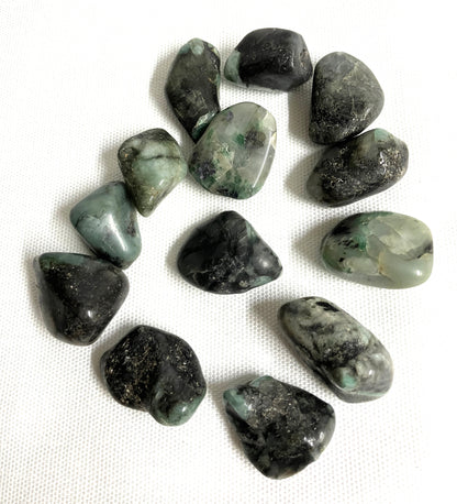 Collection of Emerald Crystals showing the formation of the stones on a white fabric background