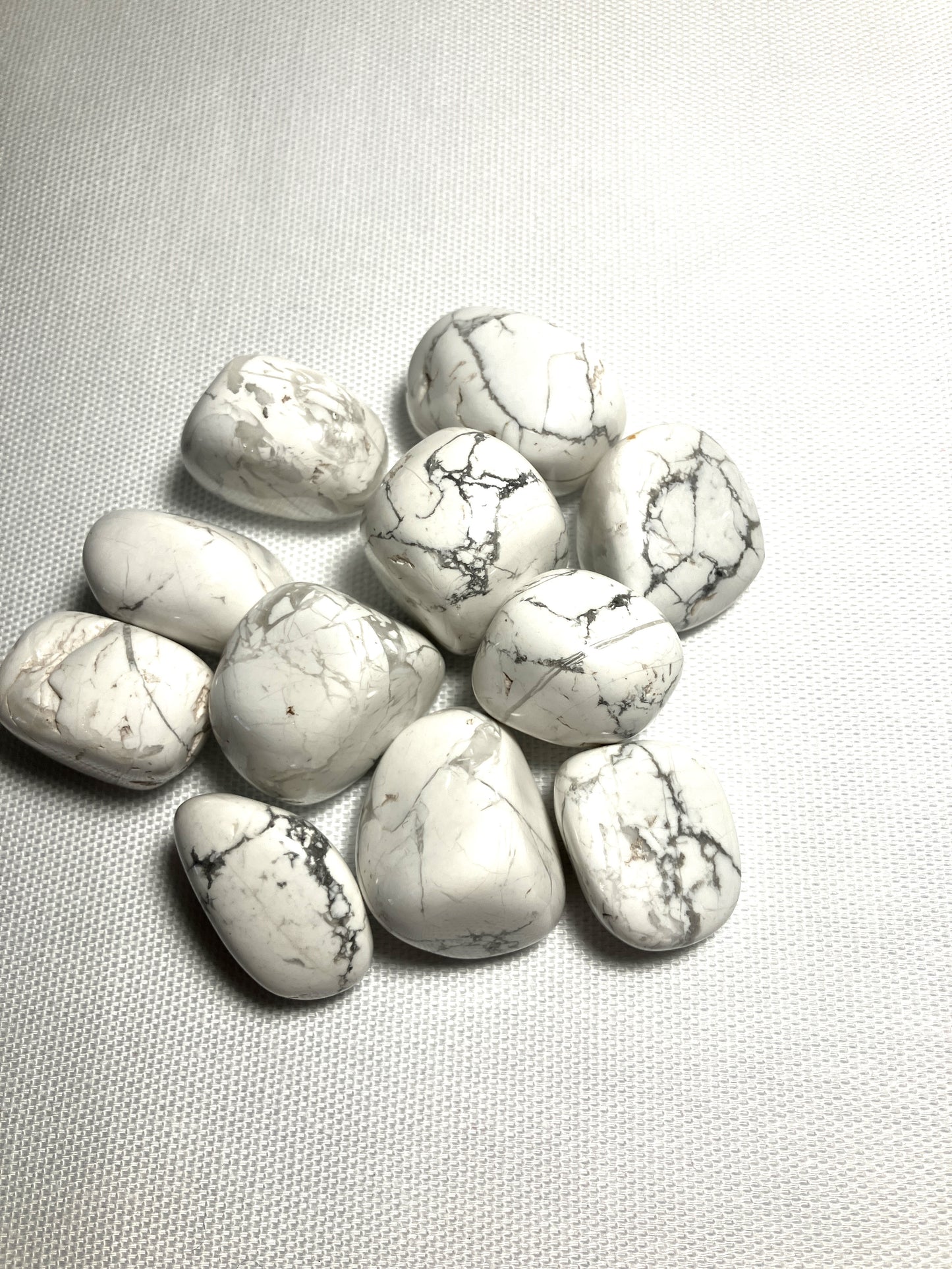 Howlite Crystals showing the front veining on a light gray fabric background