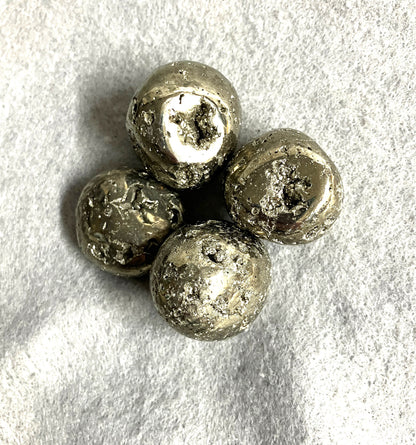 Selection of Tumbled Pyrite Crystal AKA Fool's Gold  on a textured gray surface