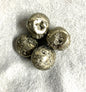 Selection of Tumbled Pyrite Crystal AKA Fool's Gold  on a textured gray surface