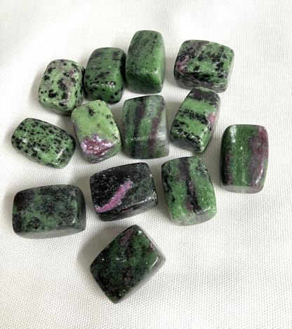 Tumbled Ruby in Zoisite Crystals on a white fabric background