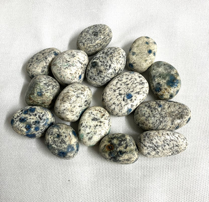 Back side of the K2 Crystals showing the speckled pattern on a white fabric background