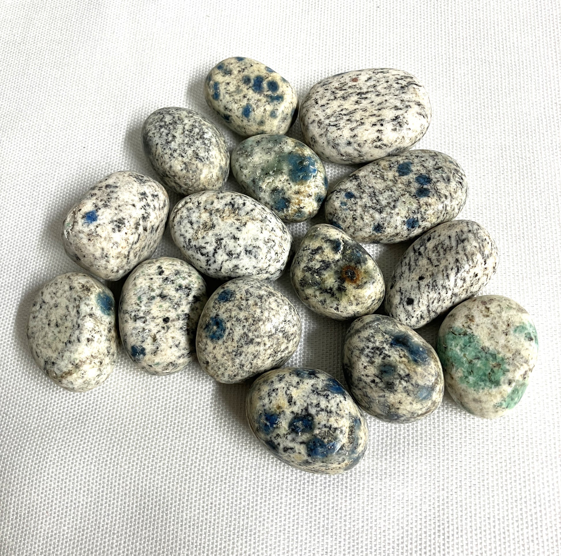 Front side of K2 Crystals with blue speckles on a white fabric background