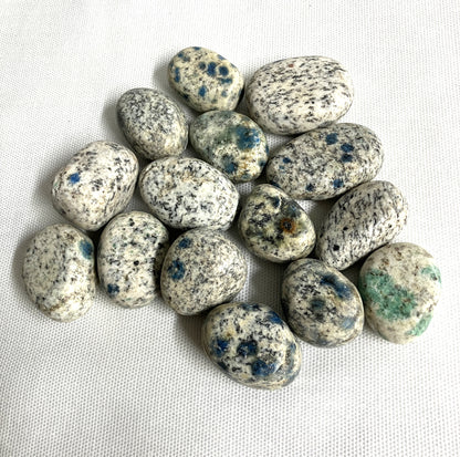 Front side of K2 Crystals with blue speckles on a white fabric background