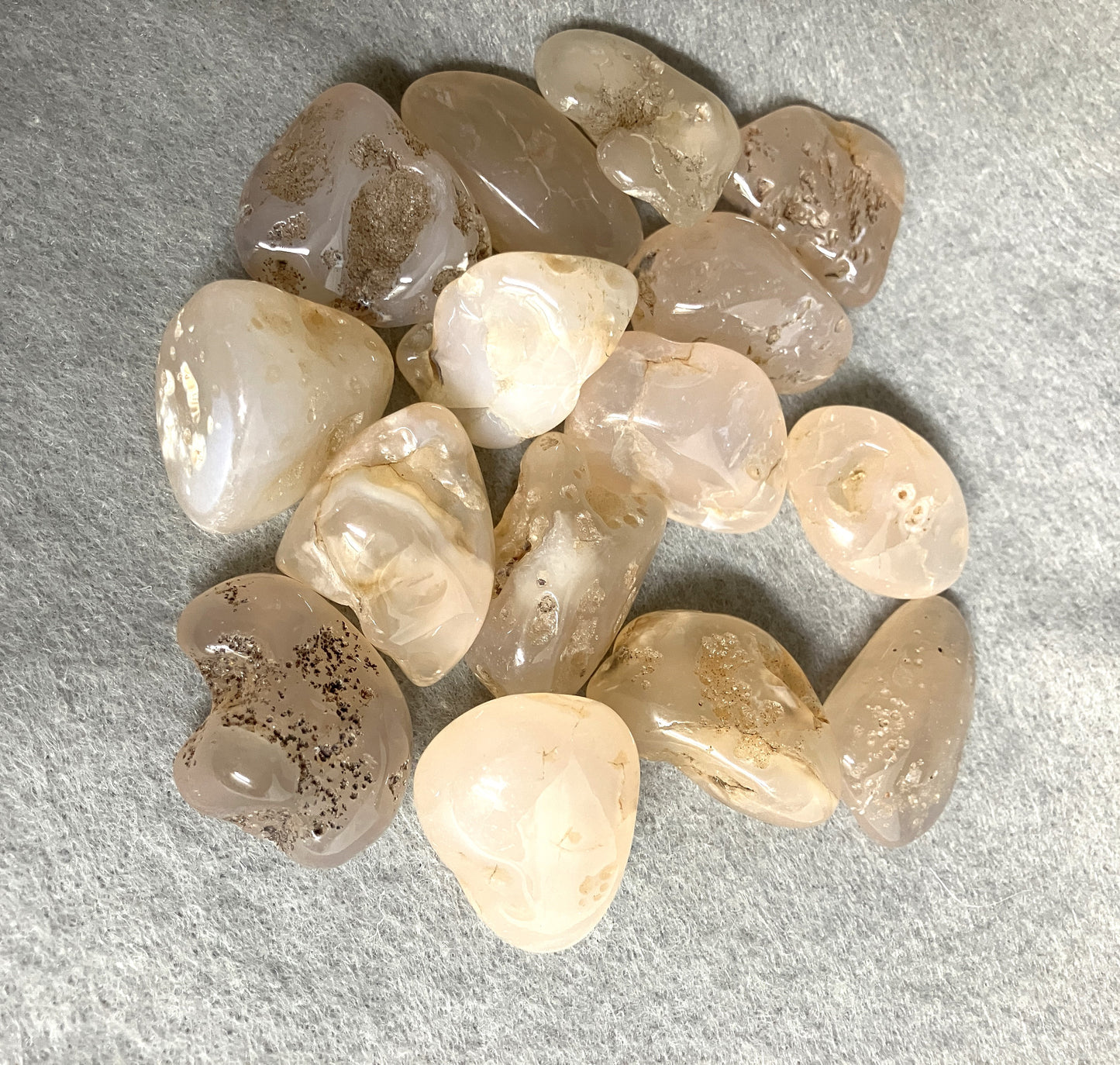 Tumbled Pink Chalcedony Crystals on a gray surface