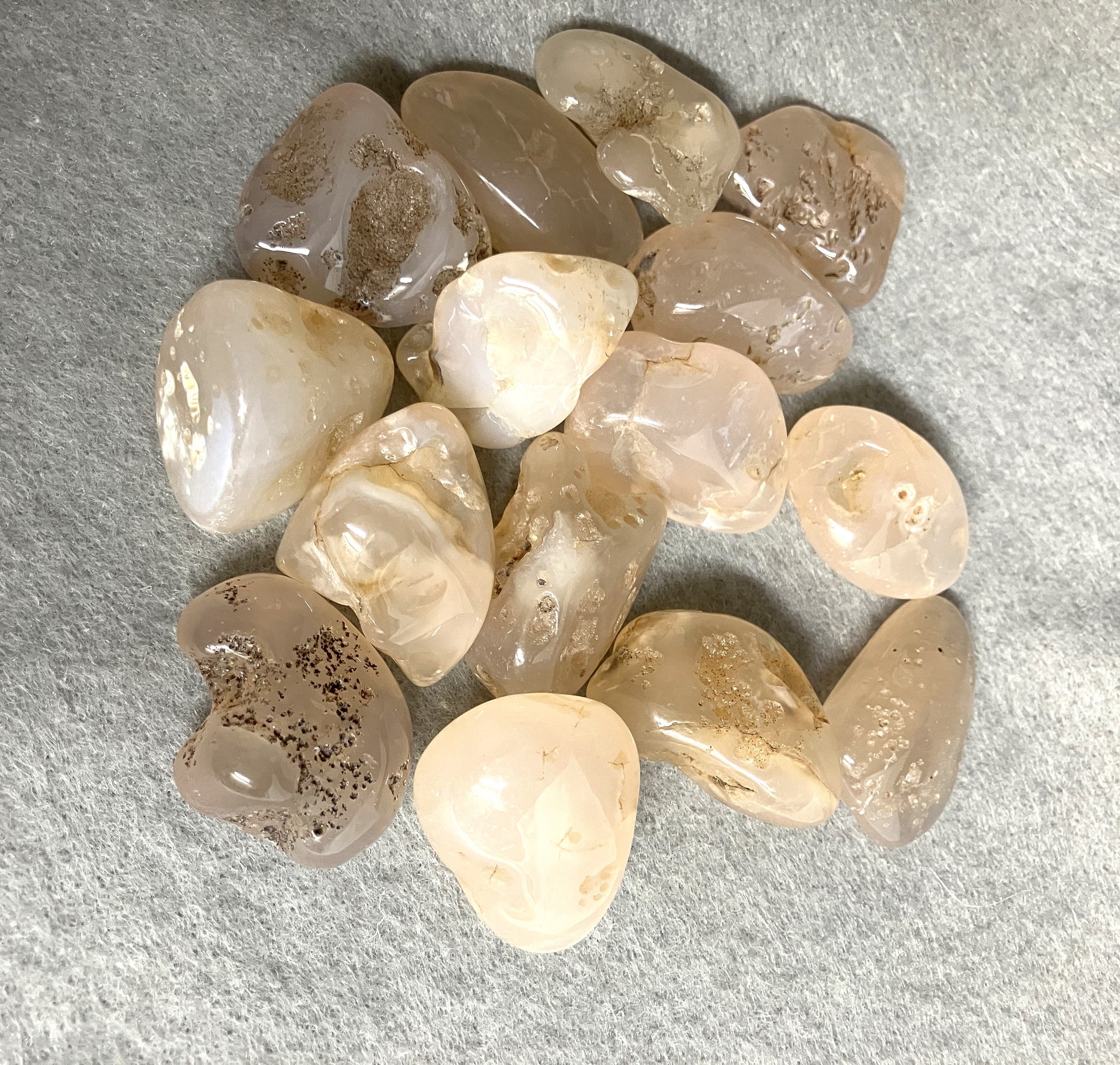Tumbled Pink Chalcedony Crystals on a gray surface