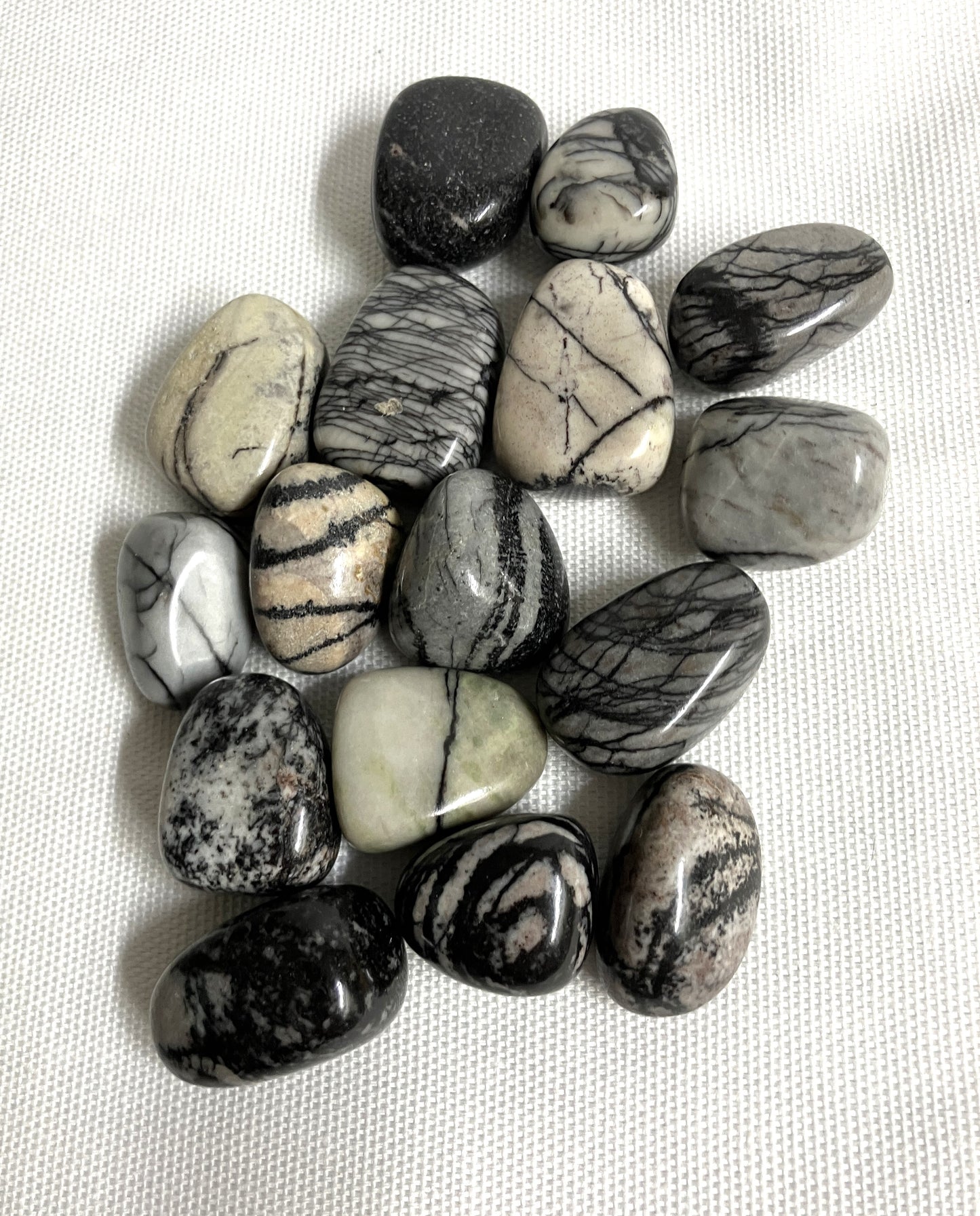 Spider Web Jasper Crystals on a white fabric background