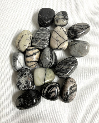 Spider Web Jasper Crystals on a white fabric background