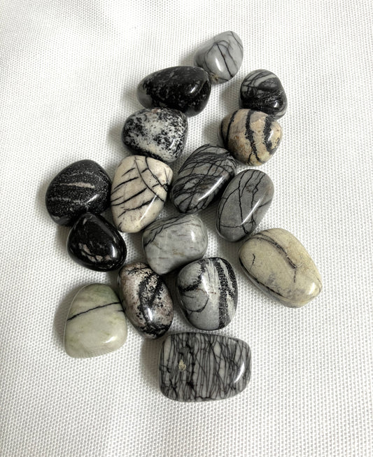 Front view of Spider Web Jasper Crystals on a white fabric background