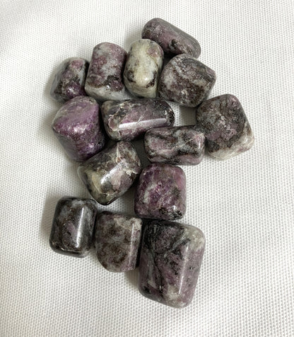 Bottom side of Pink Garnet Tumbled Crystals on a white fabric background