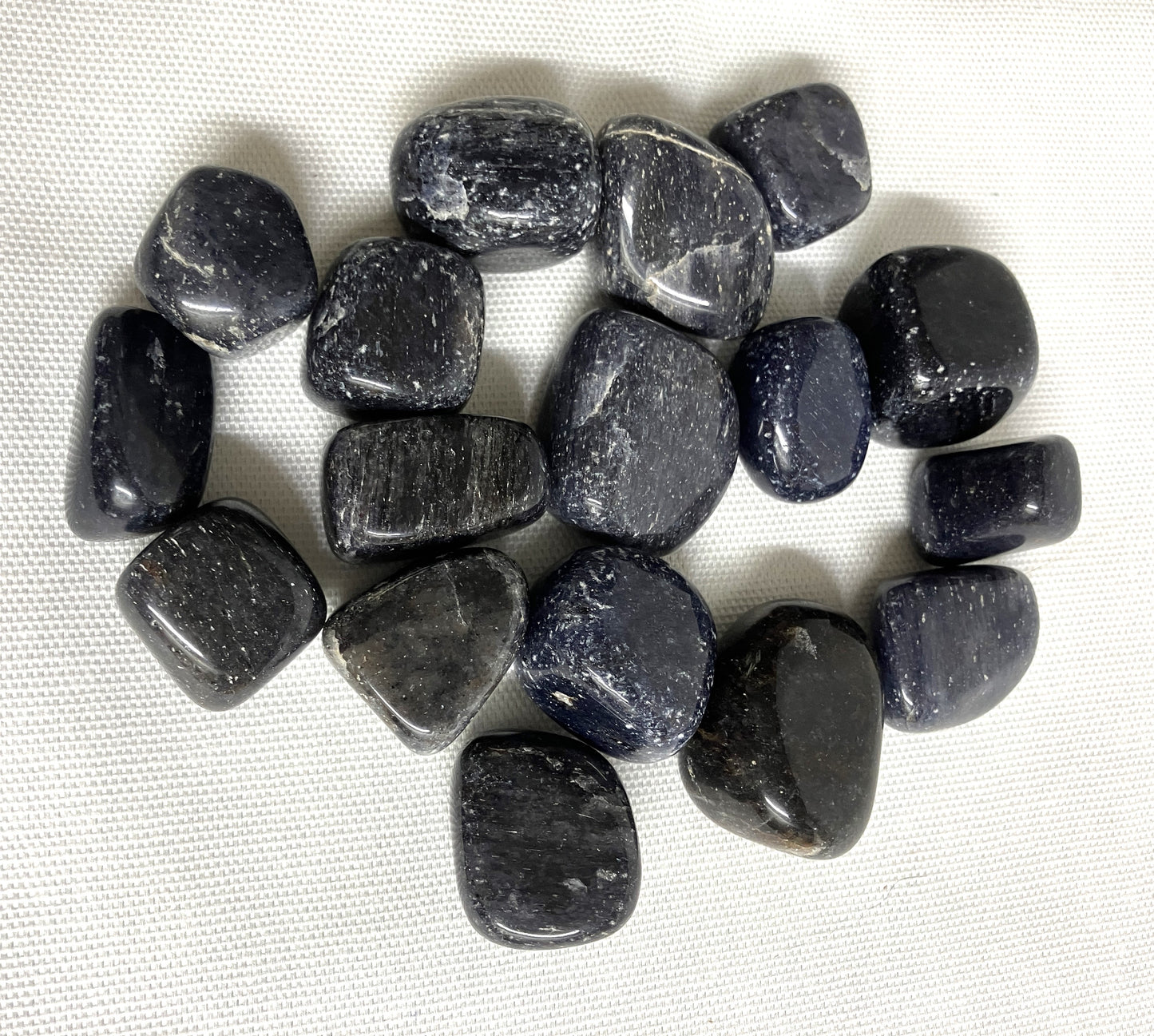 Top side of Blue Aventurine Tumbled Crystals on a white fabric background